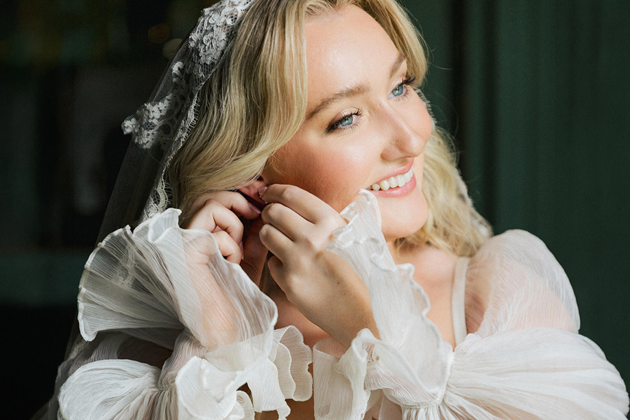 Bride smiling while getting ready, wearing natural glowing wedding makeup by Gosia May MUA.